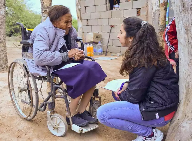 Médica atendiendo a anciana en silla de ruedas