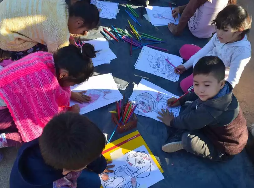 Niños pintando libros para colorear en el suelo