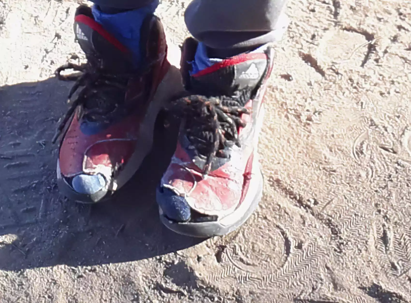 Pies de niño con zapatillas rotas.