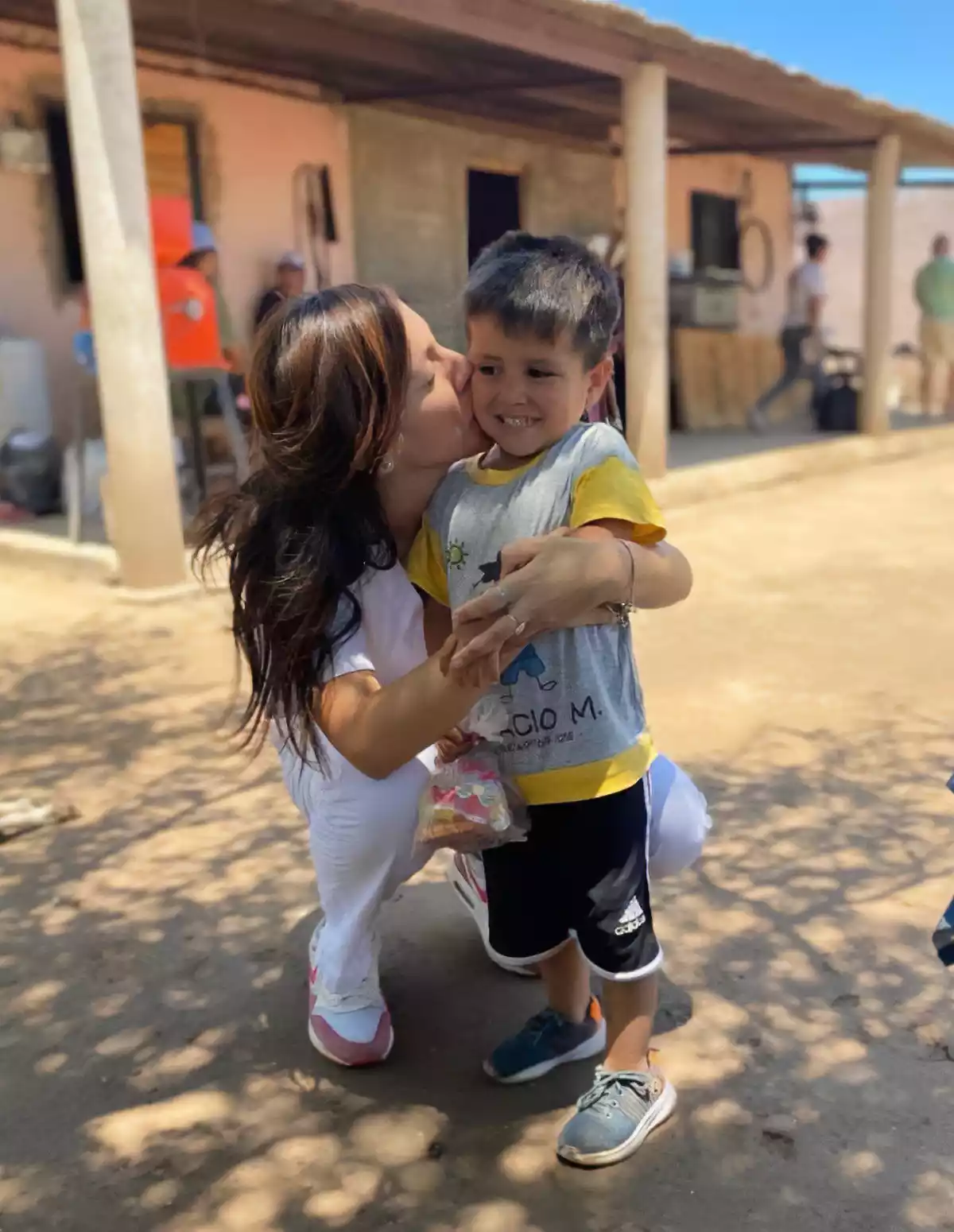 Pediatra mujer abrazando y dando un beso a un niño.